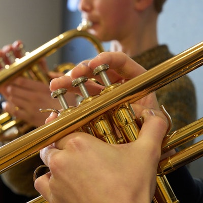 Zwei Jungen spielen im Unterricht einer Musikschule Trompete.