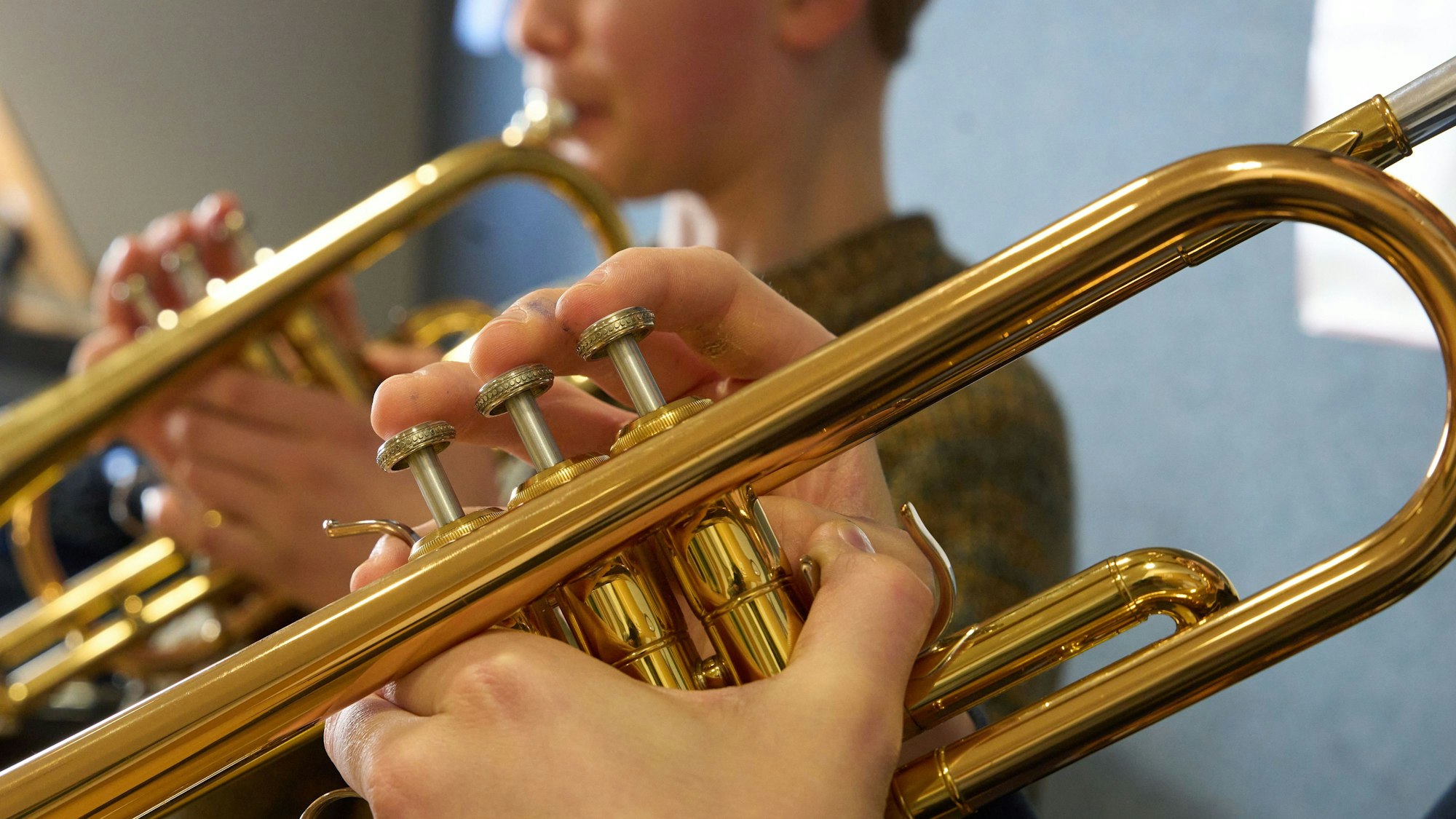 Zwei Jungen spielen im Unterricht einer Musikschule Trompete.