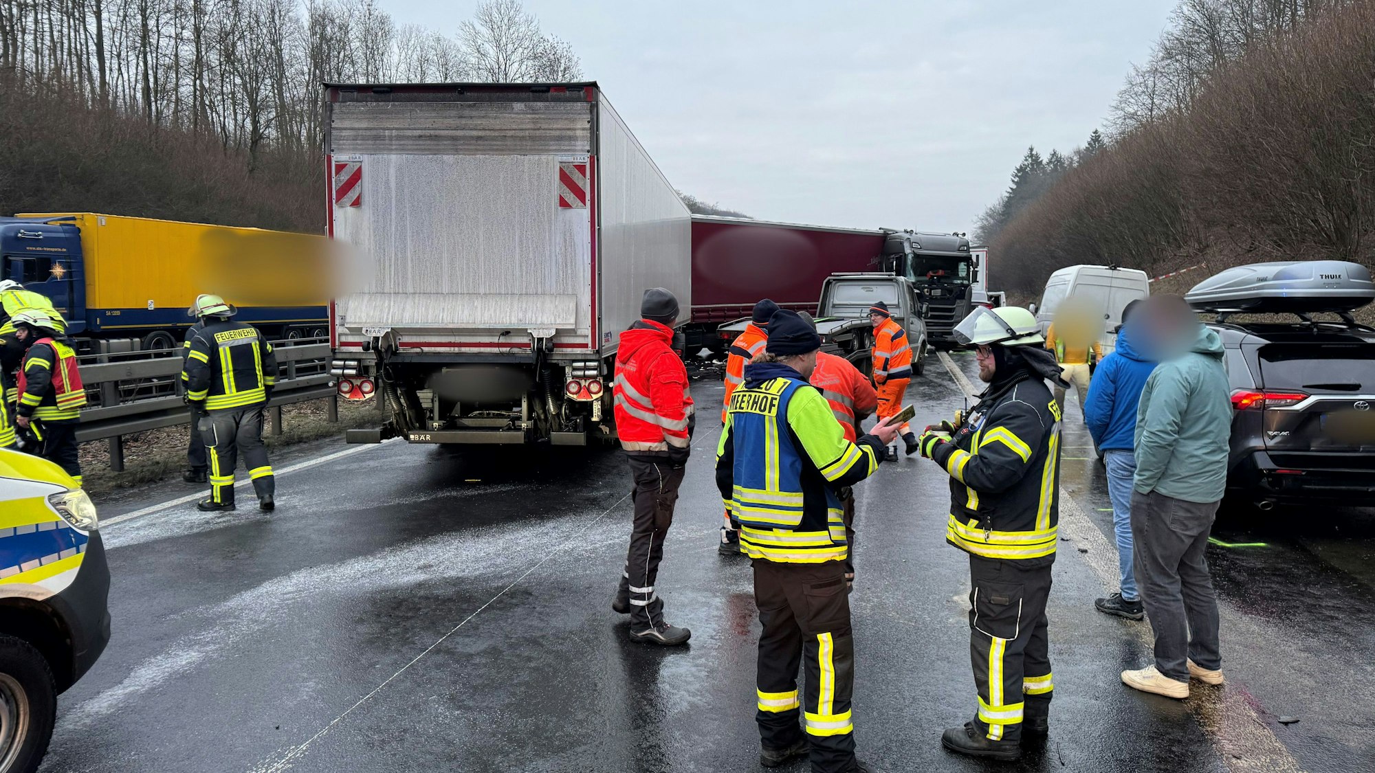 Beschädigte Fahrzeuge, Feuerwehr, Polizei und Abschleppdienste stehen auf der Fahrbahn nach einer durch Glätte ausgelösten Unfallserie mit mehreren Toten und vielen Verletzten auf der A44.