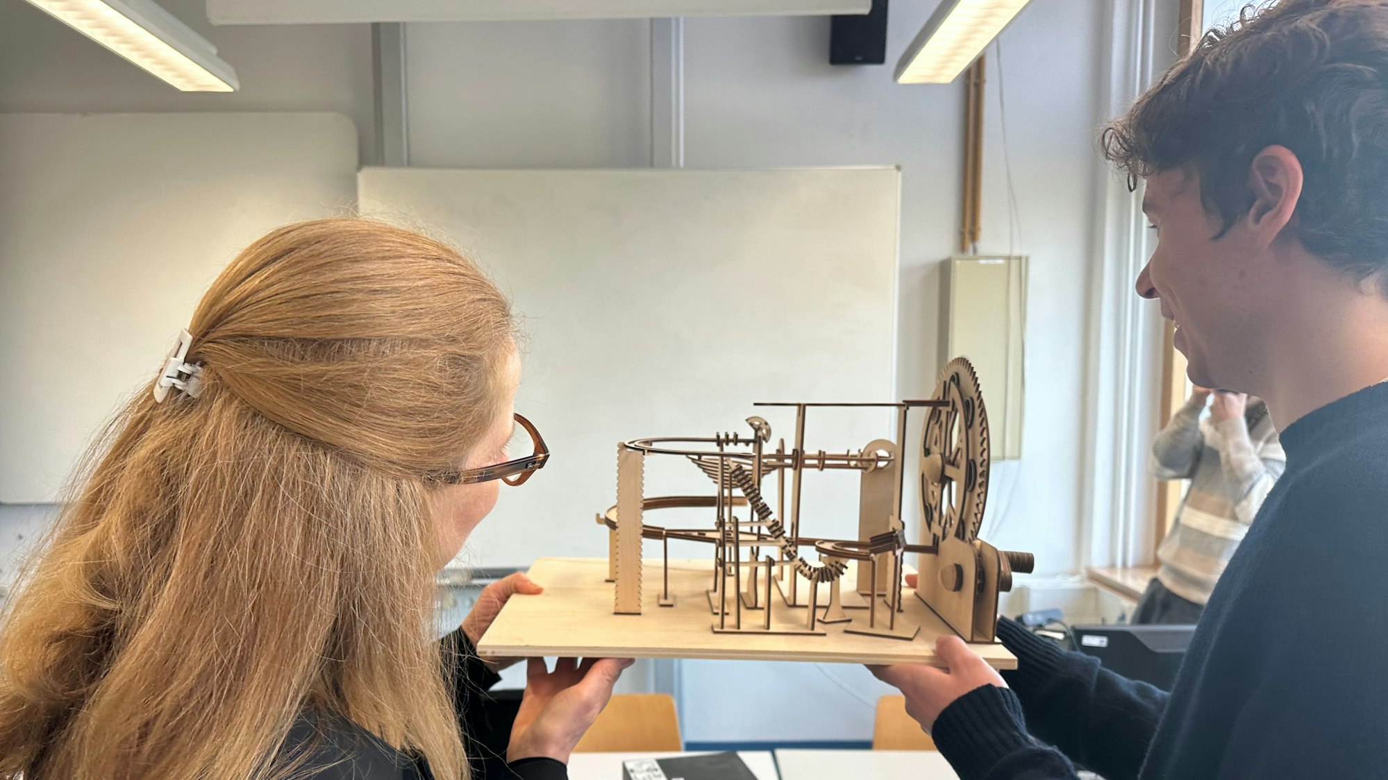 H-BRS-Präsidentin Marion Halfmann lässt sich vom Studenten Jonah Koch die Funktion seiner Holzkugelbahn erklären.