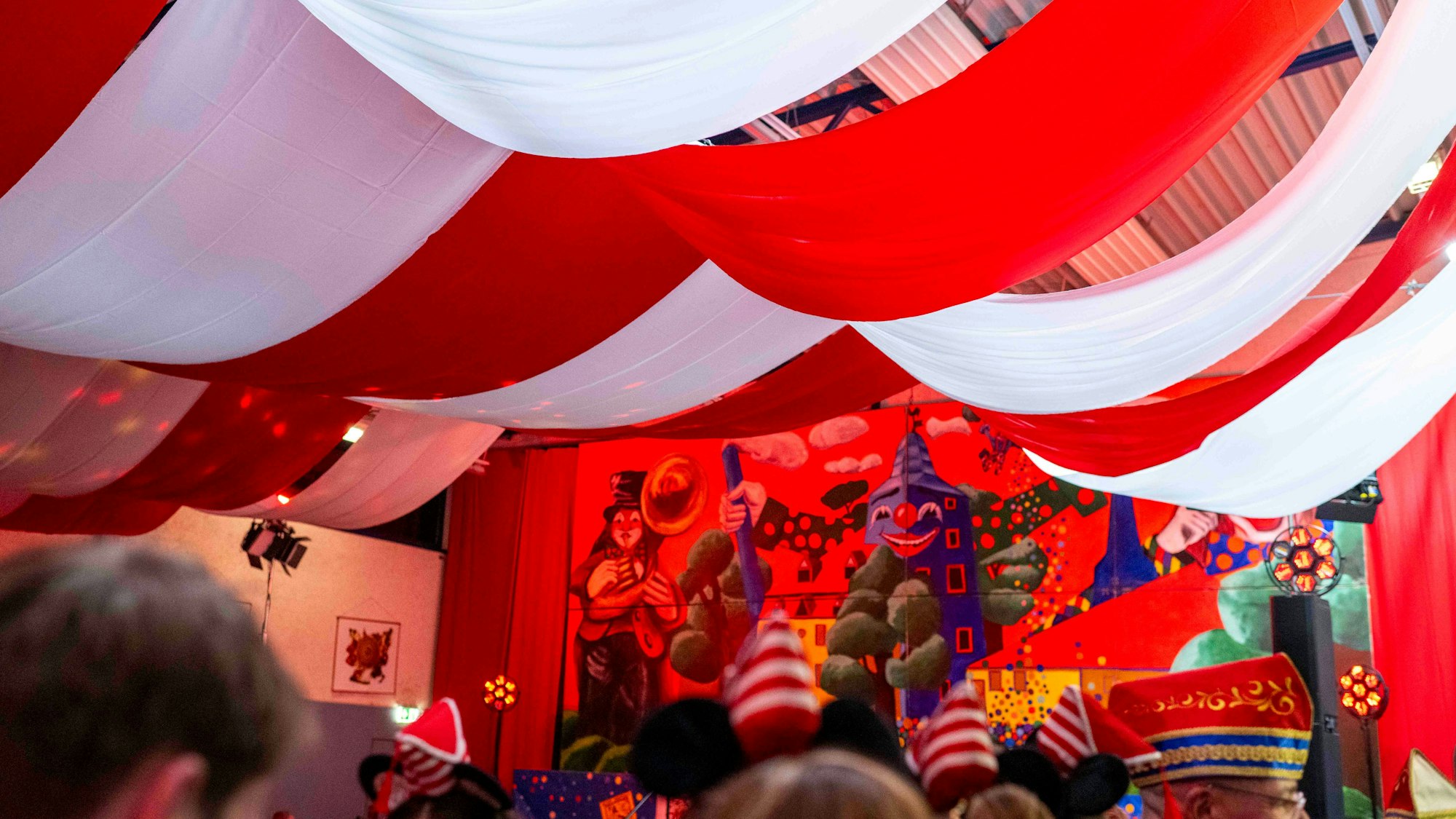 Karnevals-Sitzung in der Halle.Von der Decke hängen rot-weiße Tücher herab.