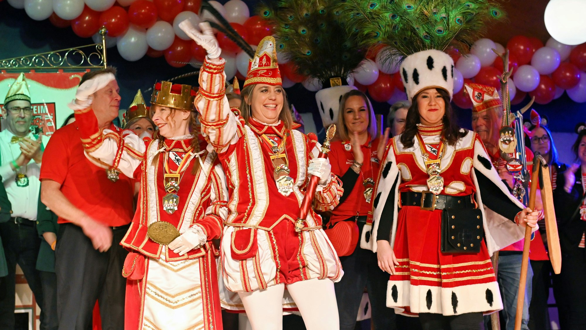 Das Palmersheimer Dreigestirn mit Jungfrau Susanne (Schultes), Prinz Elli (Elke Königshoven) und Bauer Annika (Hanke) auf der Bühne der Karnevalssitzung.
