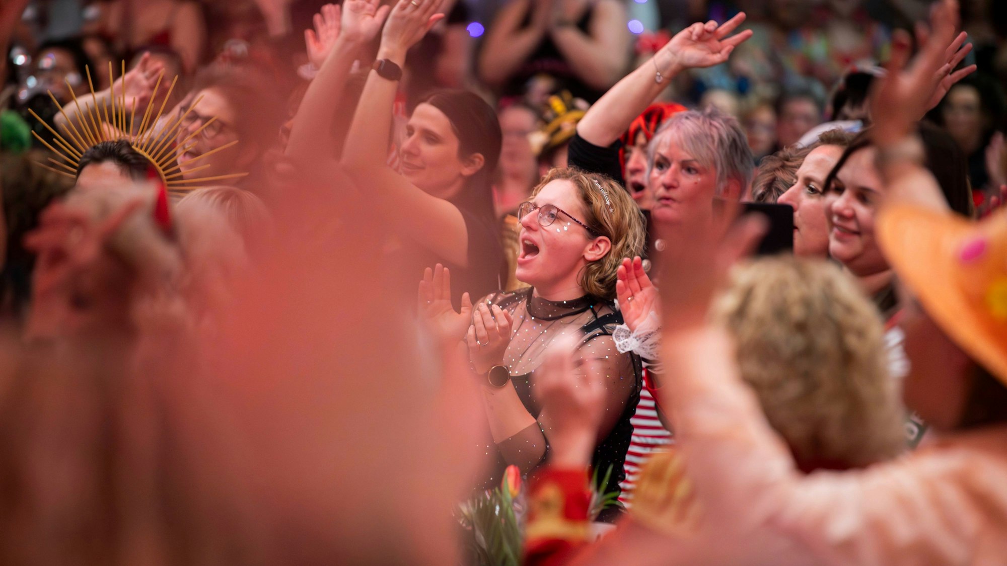 Besucherinnen der Damensitzung von Alt Oeskerche in der Alten Tuchfabrik feiern ausgelassen im Saal.