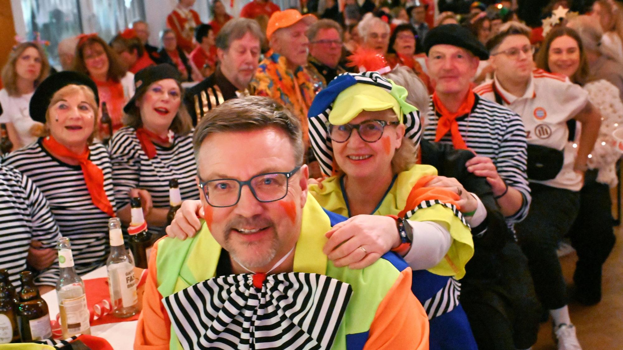 Karnevalssitzung der KG Palmersheim mit bunt kostümierten Besuchern im Saal.