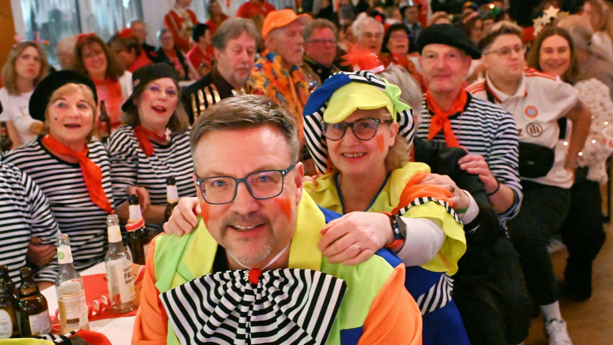 Karnevalssitzung der KG Palmersheim mit bunt kostümierten Besuchern im Saal.