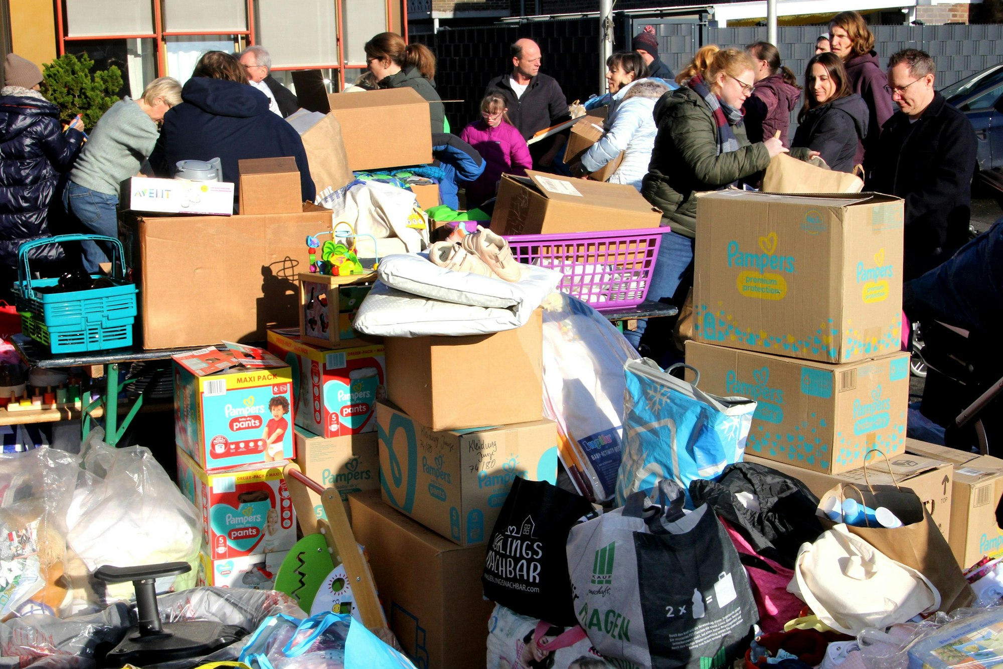 Auf dem Bild sind Kartons und Taschen voller Spenden zu sehen.