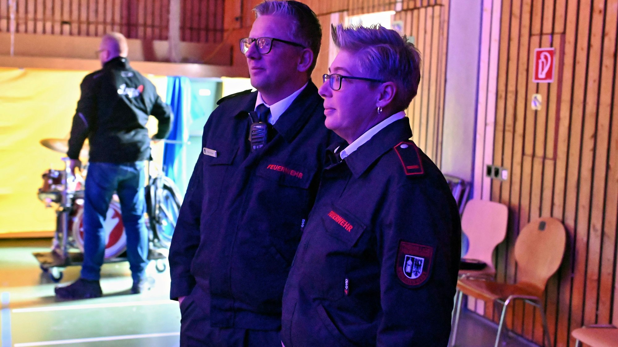 Zwei Feuerwehrleute als Brandsicherheitswache bei einer Karnevalssitzung.