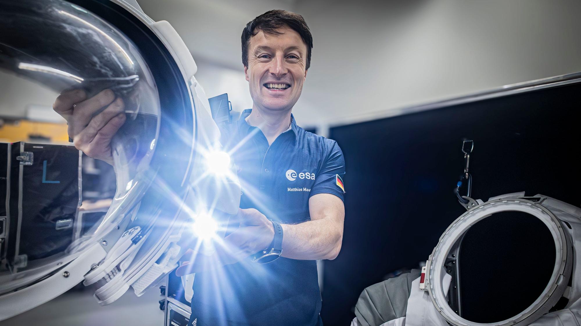 Überlebenswichtig für einen Besuch auf dem Mond: Matthias Maurer präsentiert den Helm eines Raumanzugs mit Rund-um-Blick.