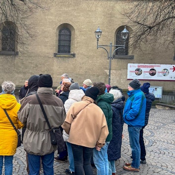 Am Adenauer-Denkmal an der Apostelnkirche erklärt Jürgen Hollstein , welche Eigenschaften Konrad Adenauer hatte.