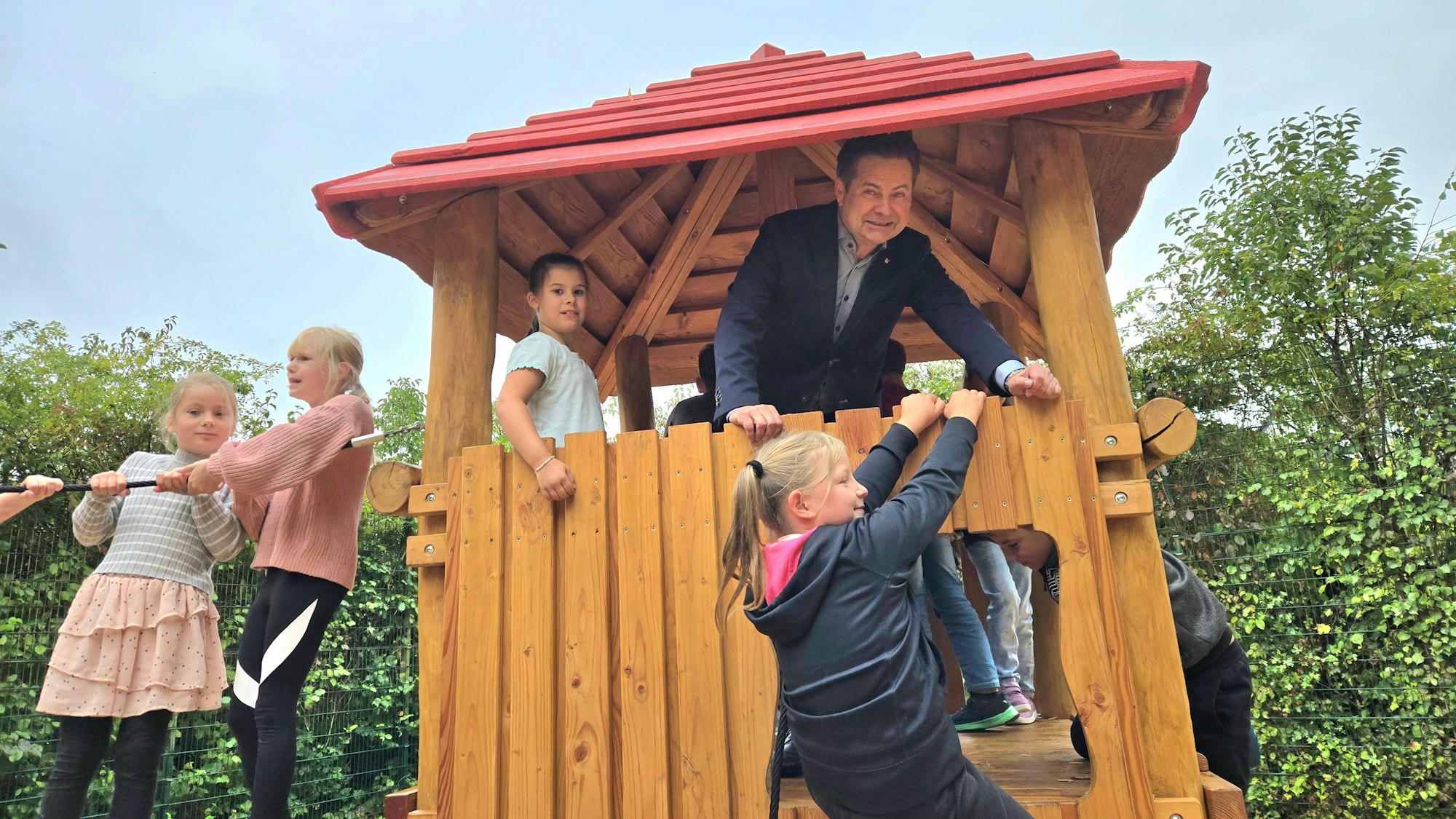 Ein Mann mit Kindern in einem Holzturm.