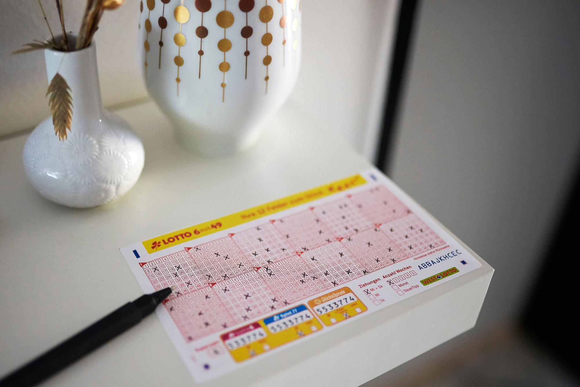 Ein LOTTO 6aus49 Schein liegt auf einem Tisch.