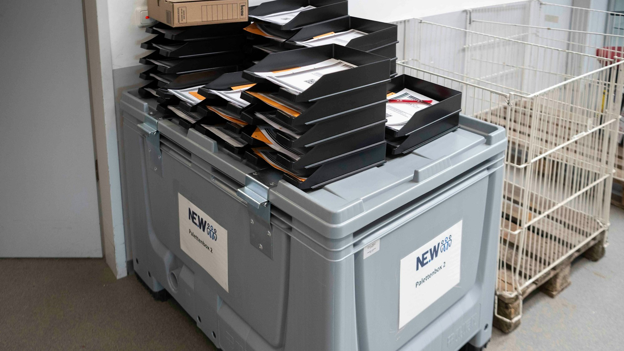 Das Bild zeigt eine recht große graue Box. Darauf stehen Aktenablagen.