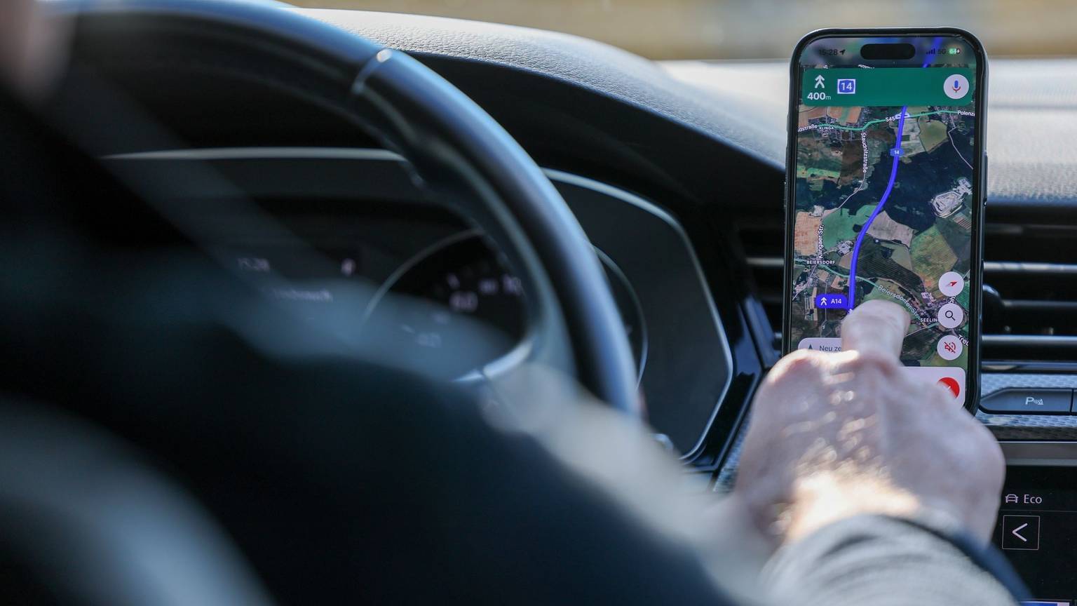 So ist es derzeit erlaubt: Das Handy steckt in der Halterung und wird nur kurz vom Fahrer beachtet. (Symbolbild)