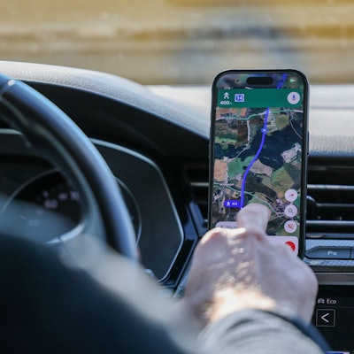 So ist es derzeit erlaubt: Das Handy steckt in der Halterung und wird nur kurz vom Fahrer beachtet. (Symbolbild)