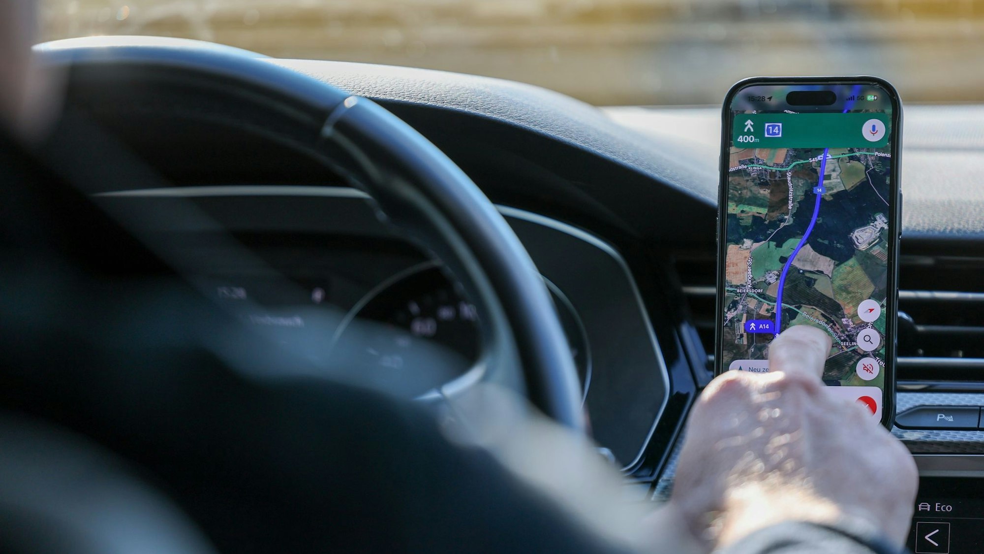 So ist es derzeit erlaubt: Das Handy steckt in der Halterung und wird nur kurz vom Fahrer beachtet. (Symbolbild)