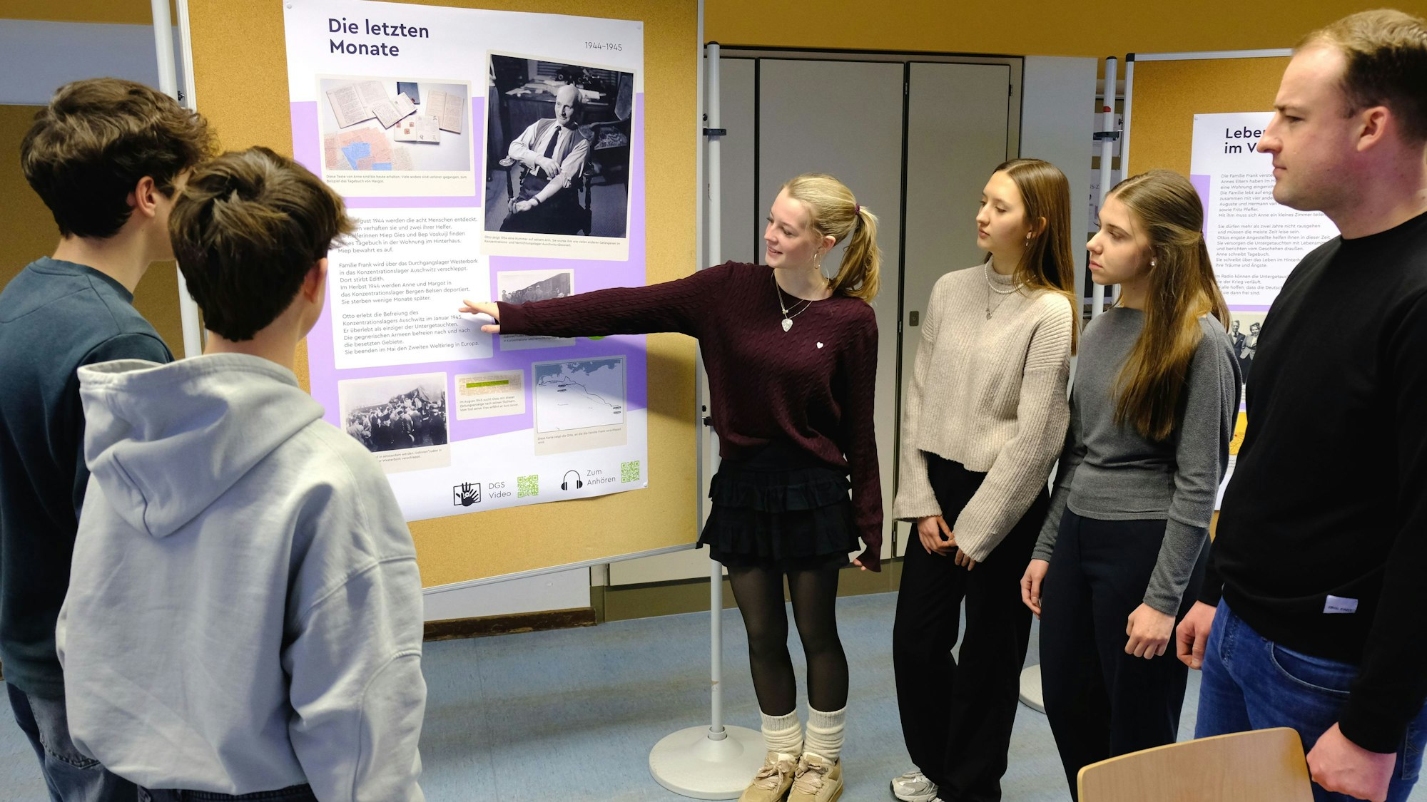 Fünf Schülerinnen und Schüler sowie ein Lehrer der Clara-Fey-Schule in Schleiden stehen zusammen und betrachten ein Plakat an einer Stellwand.