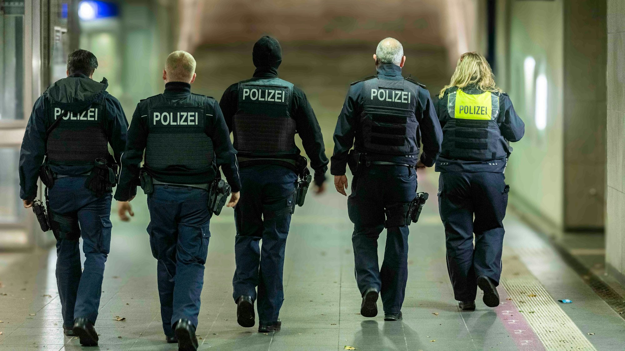 Das Bild zeigt fünft Polizeibeamte, die durch die Unterführung am Euskirchener Bahnhof patroullieren.