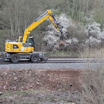 Ein Bauzug mit Bagger zieht einen Wagen (Archivbild).