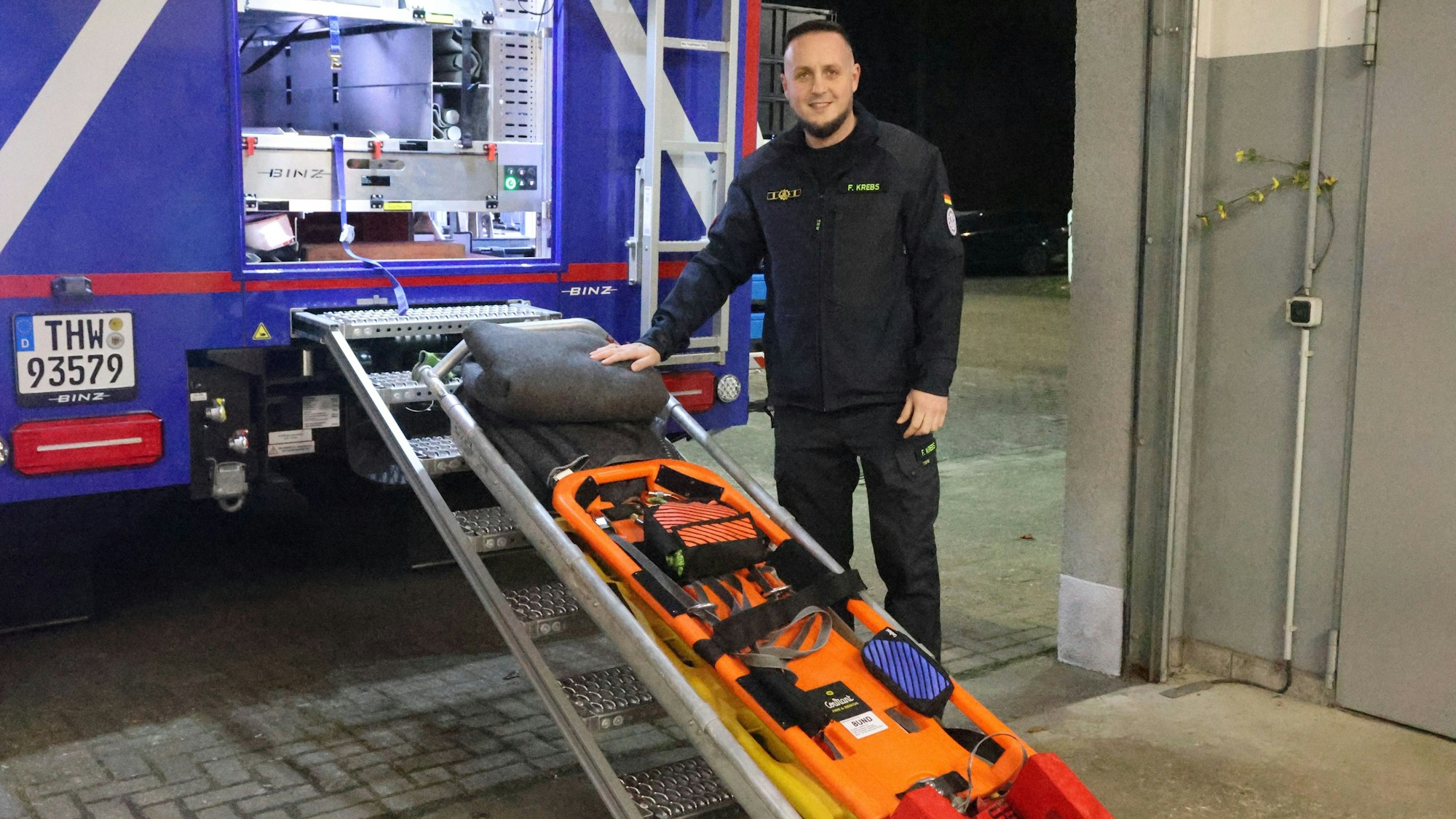 Florian Krebs, Ortsbeauftragter des THW in der Marktstadt Waldbröl, zeigt einen Schleifkorb und ein Spineboard. Mit diesen Geräten können Menschn gerettet werden.