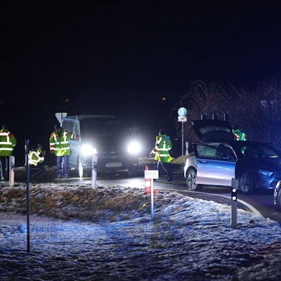 Fahrzeuge und Polizeikräfte stehen nach einer Verfolgungsjagd an einer Straße in Weißenburg.