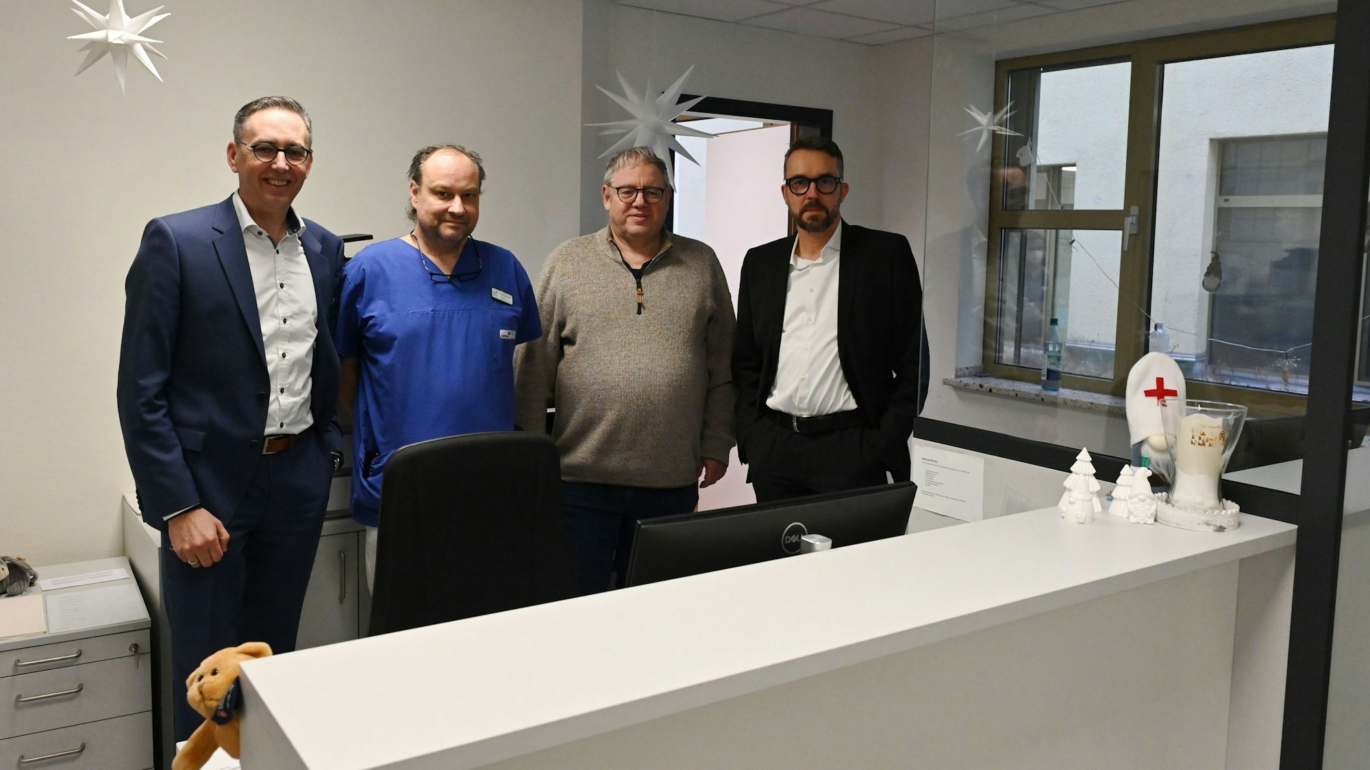 Vier Männer stehen hinter einem Tresen. Dort werden im Kreiskrankenhaus Mechernich künftig die Notfallpatienten ersteingeschätzt.