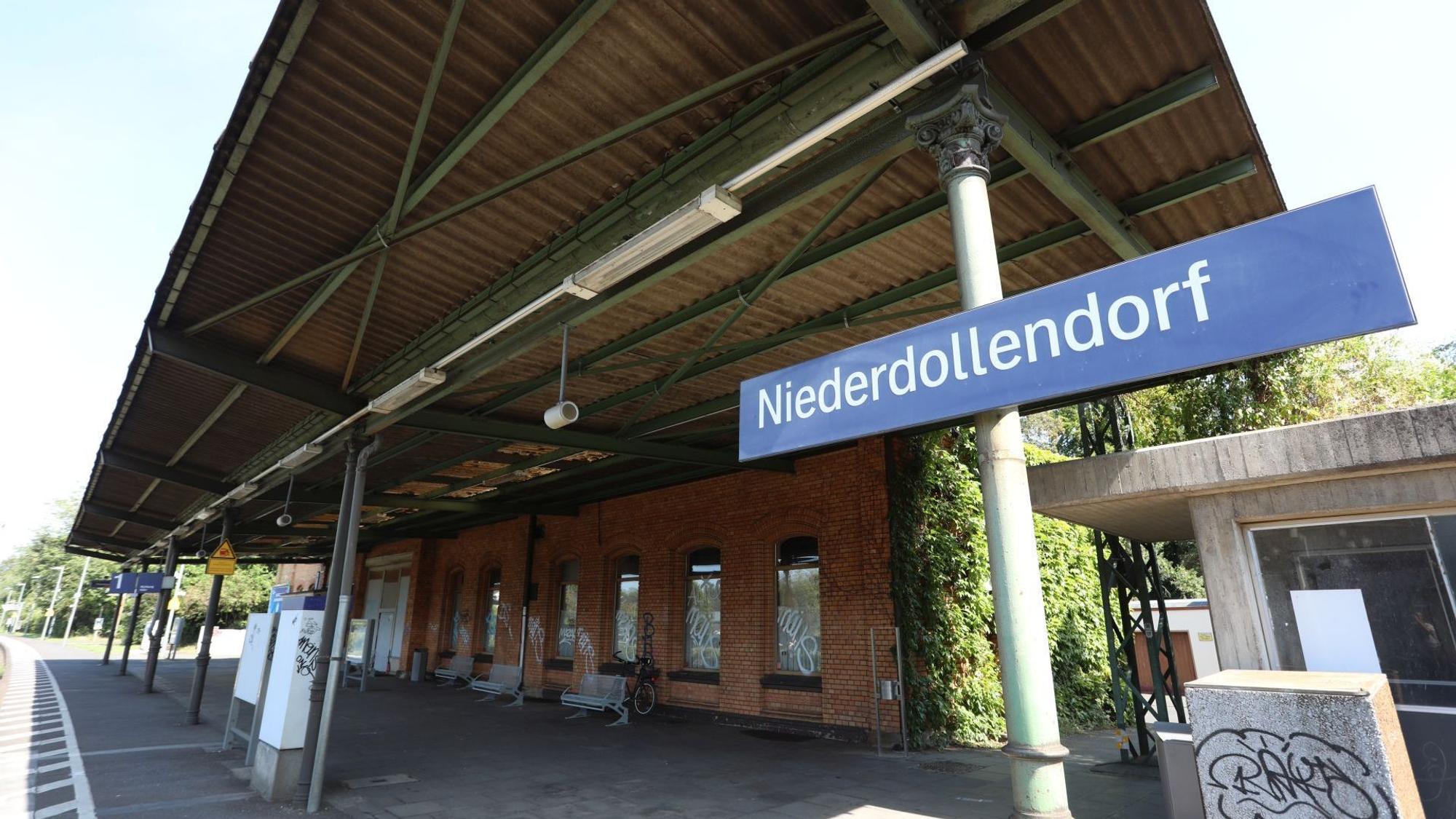 Gleis 1 vor dem Gebäude des Bahnhofes, an der Seite ein Schild mit dem Schriftzug Niederdollendorf.