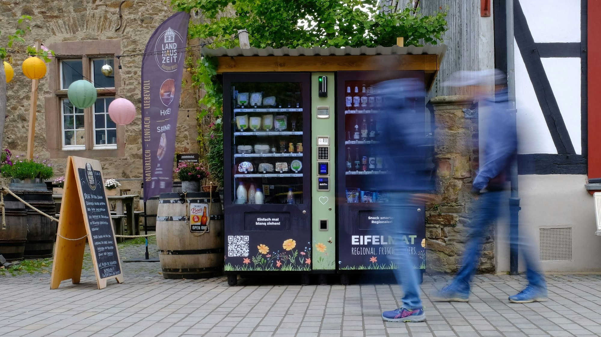 Zwei Männer gehen an zwei Verkaufsautomaten vorbei. Beide Männer sind bewegungsunscharf.