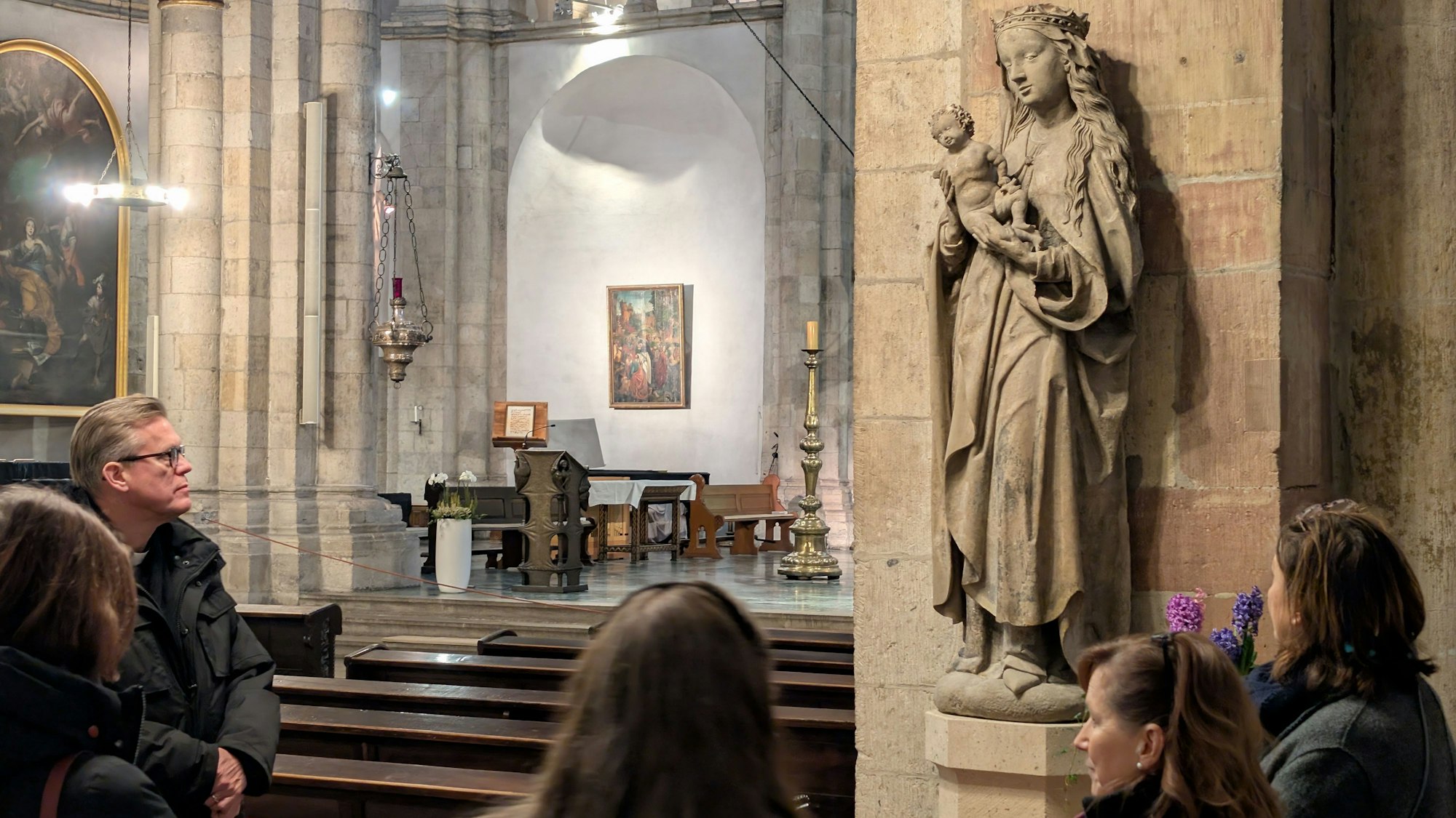 Innenraum St. Aposteln mit Menschen und restaurierter Muttergottes