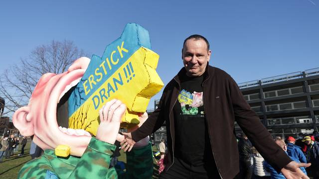 Jacques Tilly, Karnevals-Wagenbauer, steht neben seiner kreierten Figur, die Putin zeigt, wie er an der Ukraine erstickt.
