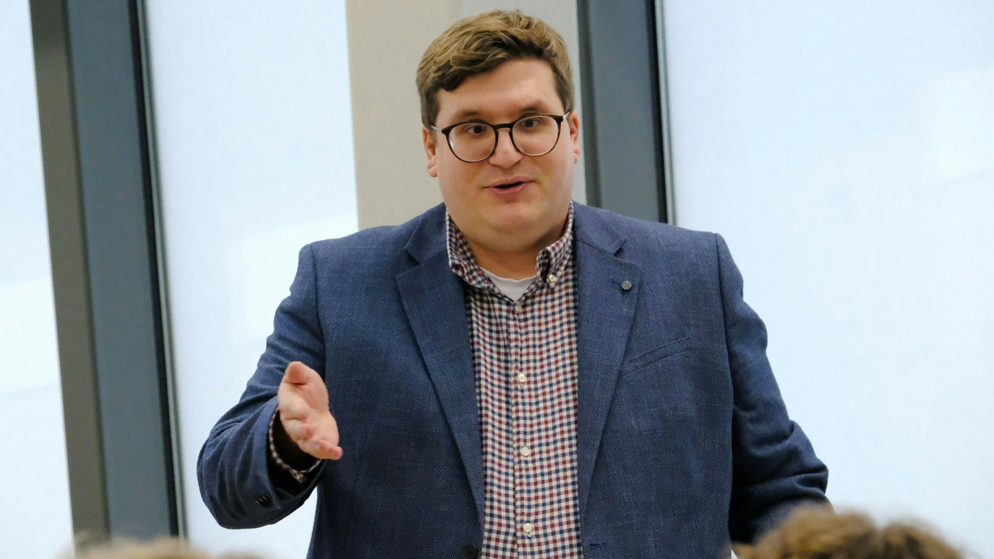 Marc Meyer mit Brille und Jackett über einem karierten Hemd bei seiner Ansprache.