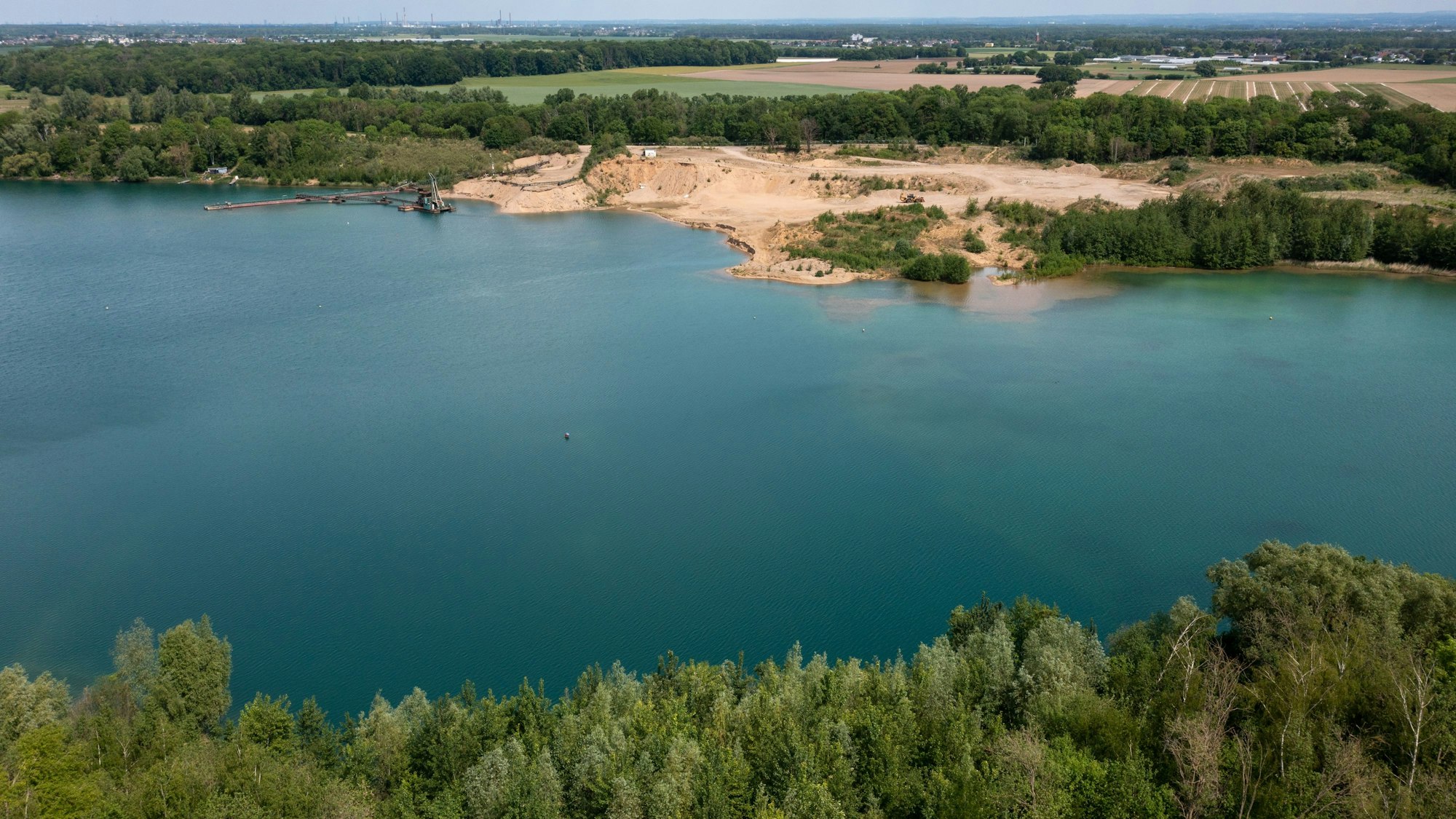 Im Vordergrund ein See, im Hintergrund der Uferbereich.