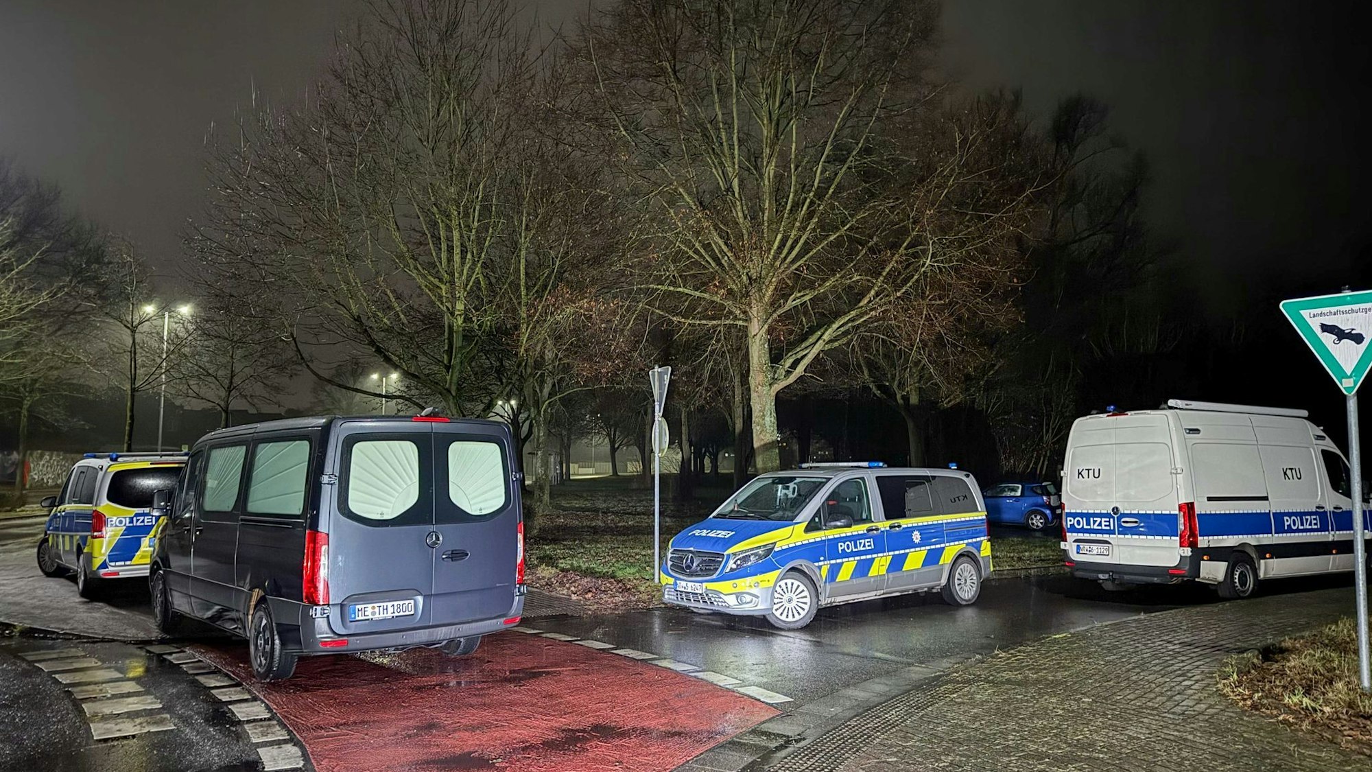 Das Bild zeigt Polizeiwagen an dem Fundort einer Leiche in Dormagen. Foto: Vincent Kempf/dpa