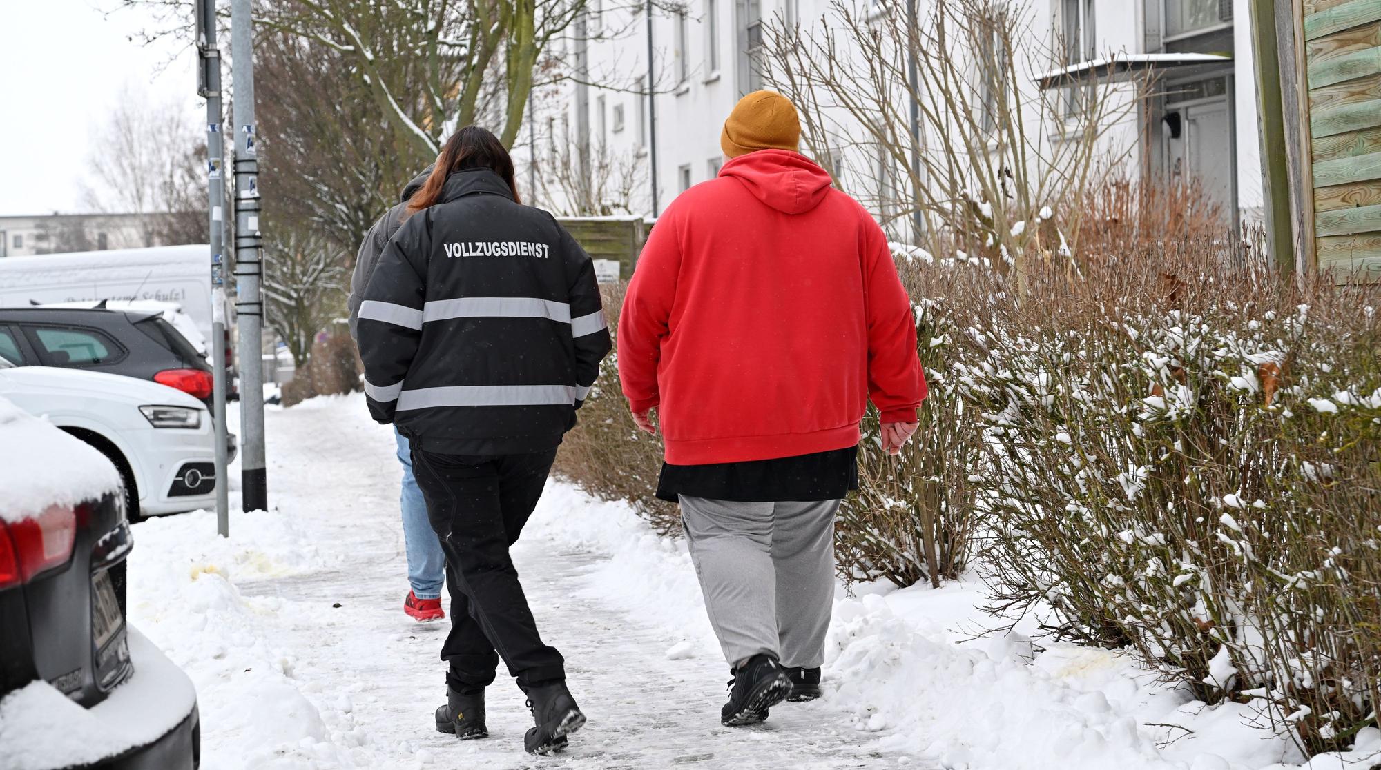 Sandra Hesse (l), Leiterin des Vollzugsdienstes im Landkreis Nordhausen, begleitet einen jungen Bürgergeldempfänger zum Dienstfahrzeug.