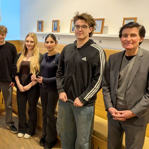 Drei Erwachsene und eine Gruppe von Schülern im Raum der Stille in Vogelsang IP.