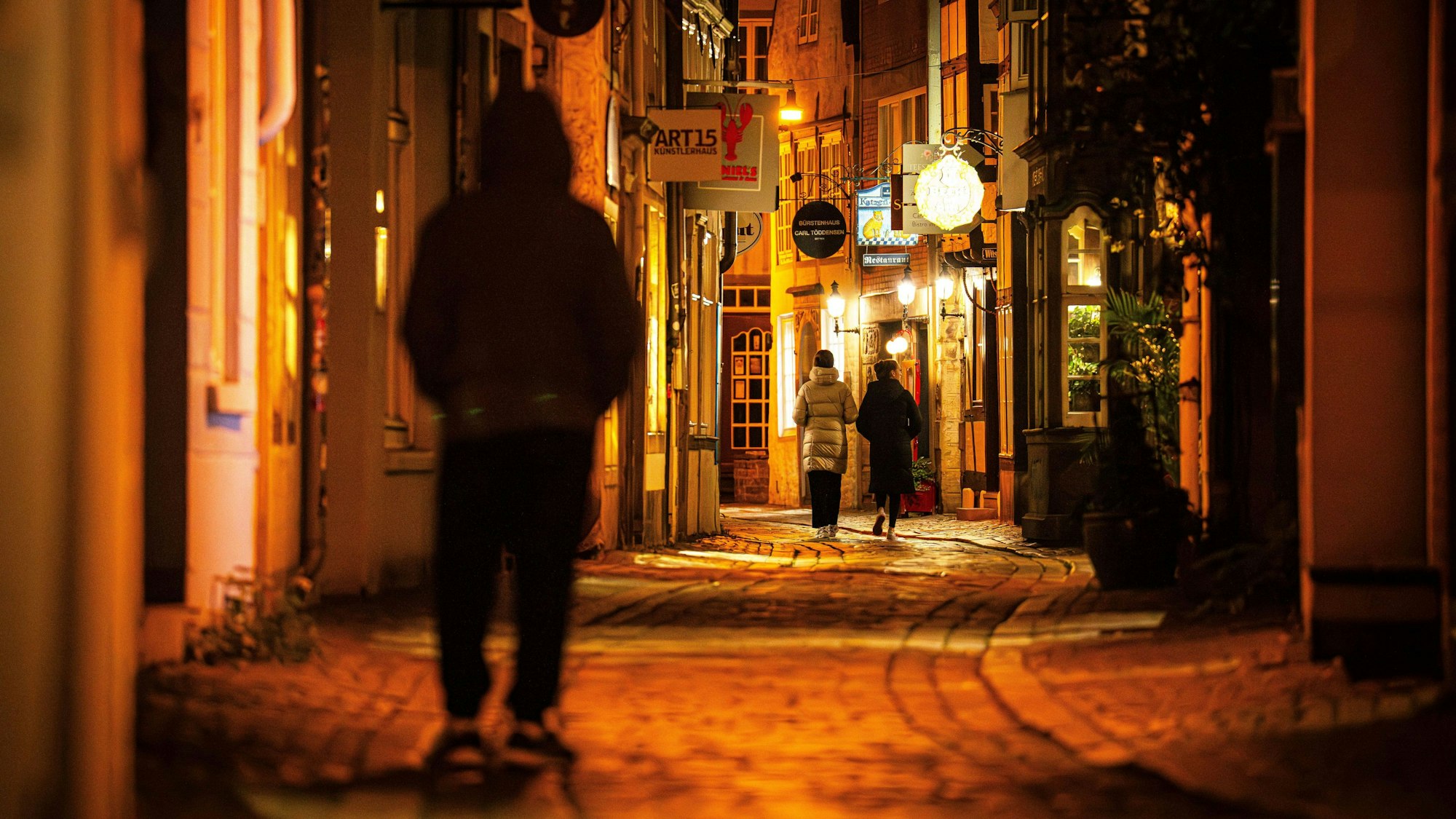 Passanten gehen am späten Abend in einer dunklen Gasse. Nachteulen leiden einer im „Journal of the American Heart Association“ veröffentlichten Studie zufolge häufiger an Herz-Kreislauf-Erkrankungen. (Symbolbild)