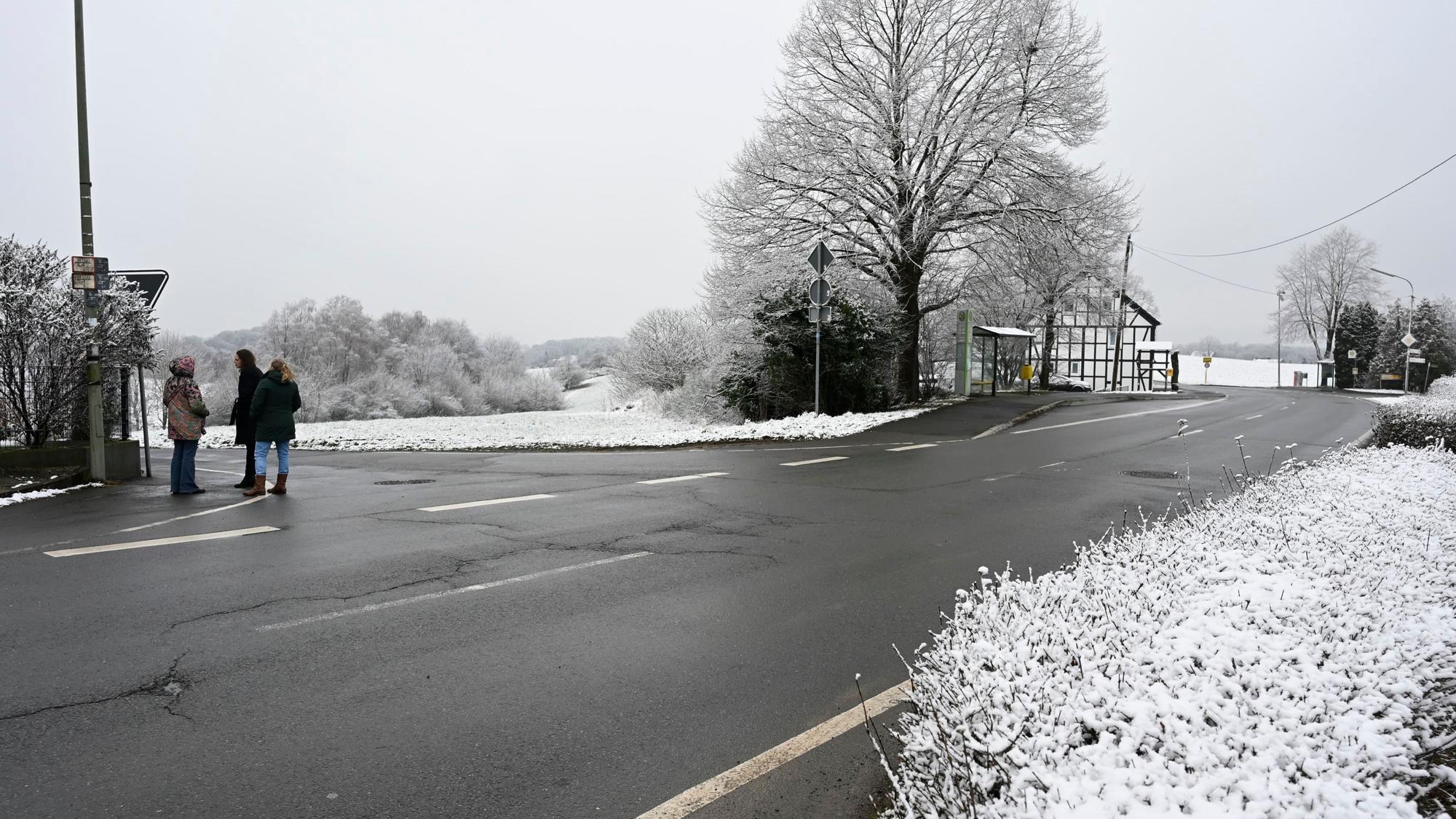 Zu sehen ist eine Straße, die eine Kurve macht. Es hat offensichtlich geschneit.