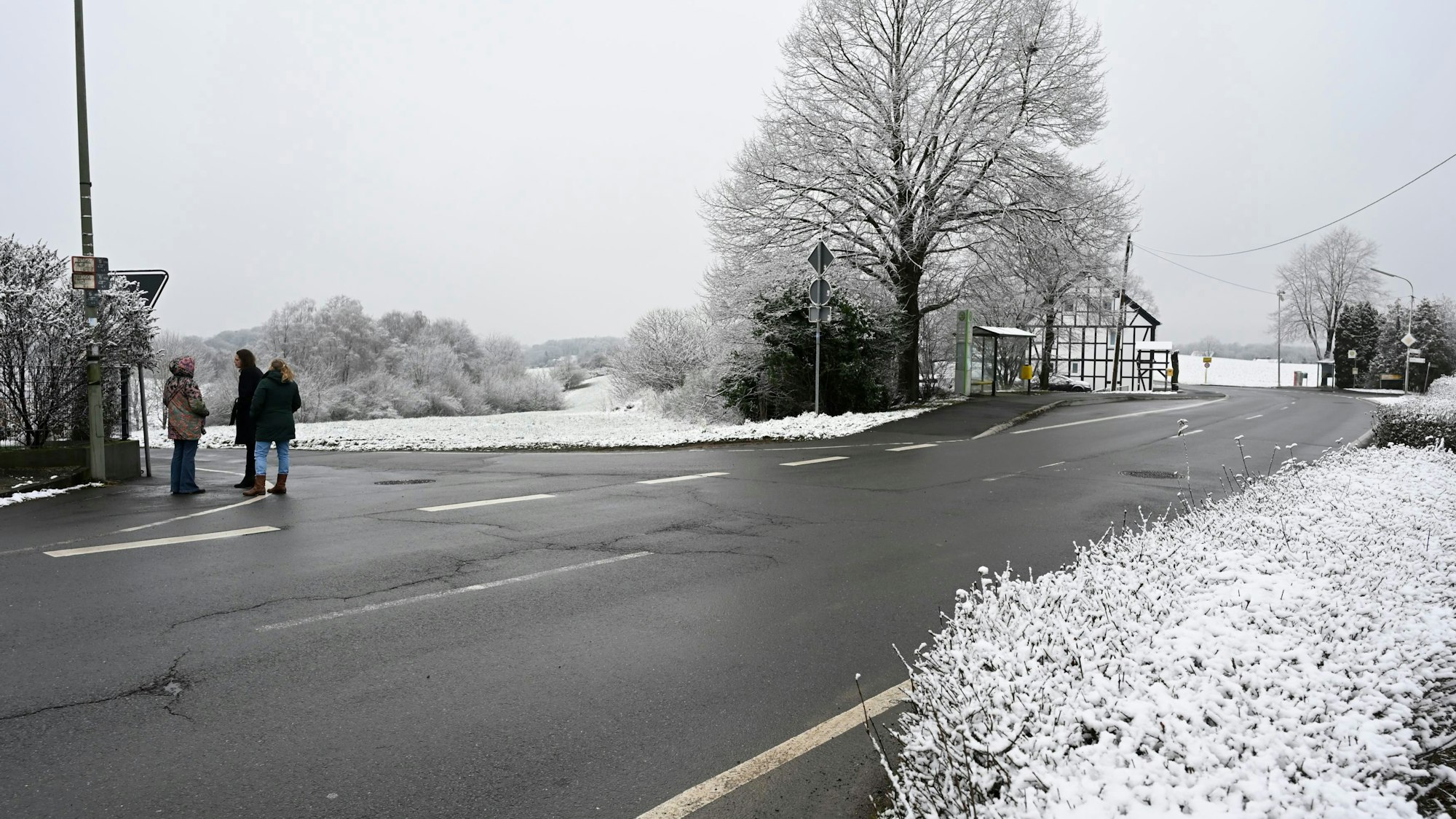 Zu sehen ist eine Straße, die eine Kurve macht. Es hat offensichtlich geschneit.