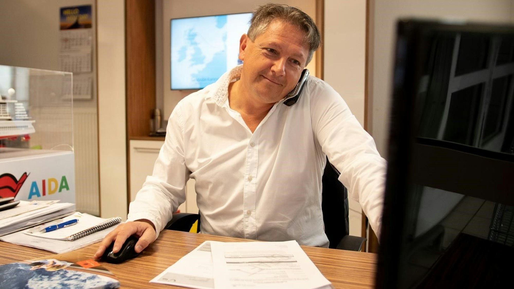 Das Bild zeigt Markus Birkenheuer an seinem Schreibtisch. Er sitzt vor einem Computer.