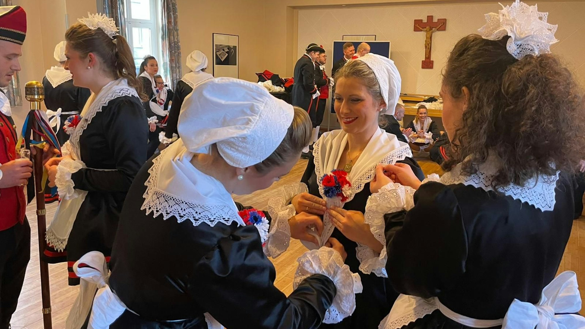 Teamwork: Die Tänzerinnen und Tänzer unterstützen sich bei der Vorbereitung der Trachten