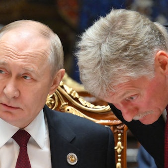 Russlands Präsident Wladimir Putin (l.) spricht mit Kremlsprecher Dmitri Peskow. (Archivbild)