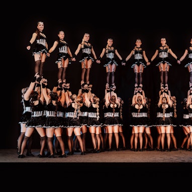 Die Mitglieder der Tanzgruppe haben sich zu einer Menschenpyramide formiert.