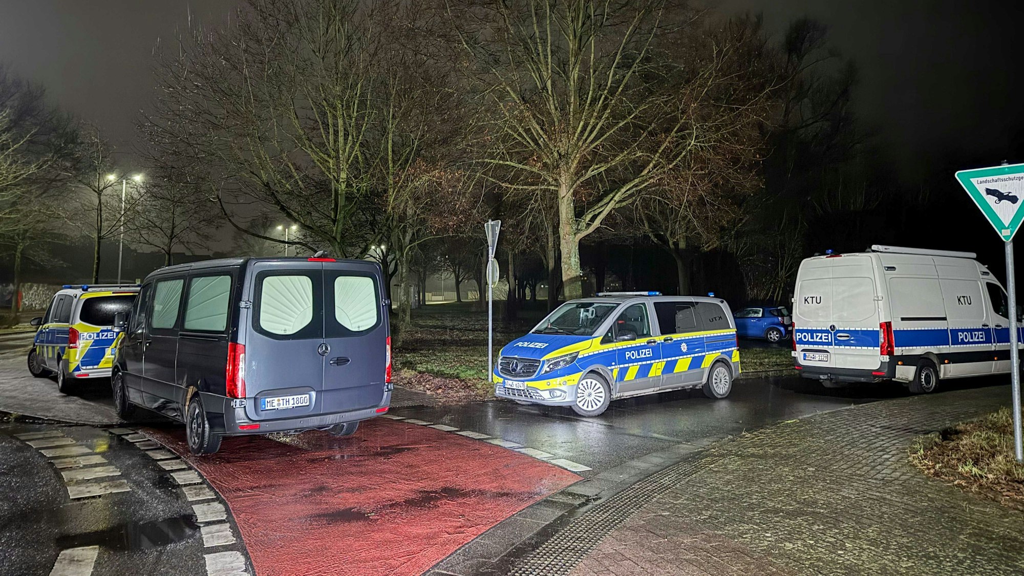 Einsatzfahrzeuge stehen an einem Waldgebiet in Dormagen, nachdem die Leiche eines Jungen gefunden wurde.