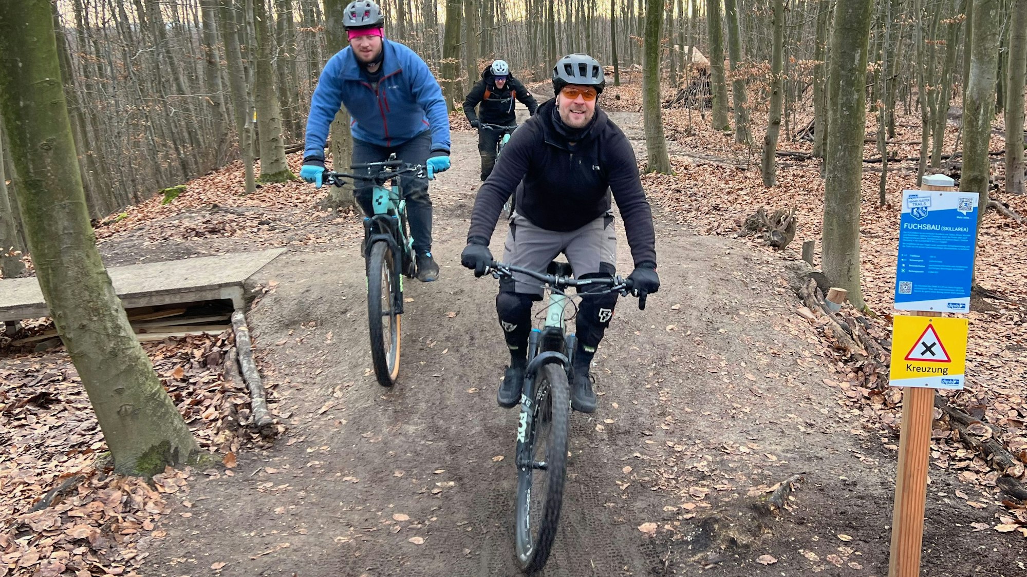 Auf dem Bild sind Mountain-Biker in einem Wald zu sehen