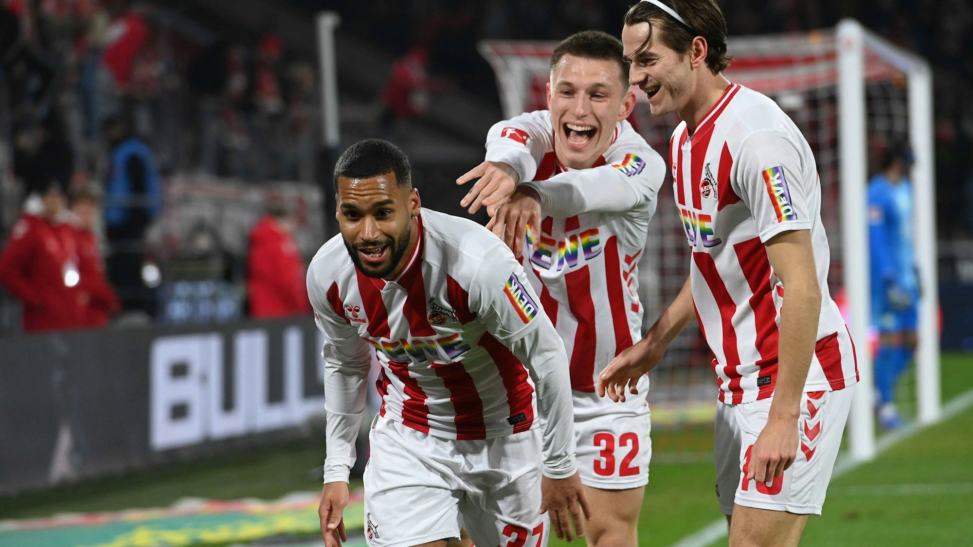 Linton Maina (l.) jubelt mit Kristoffer Lund und Jakub Kaminski (r.) über das Siegtor des 1. FC Köln gegen den VfL Wolfsburg.
