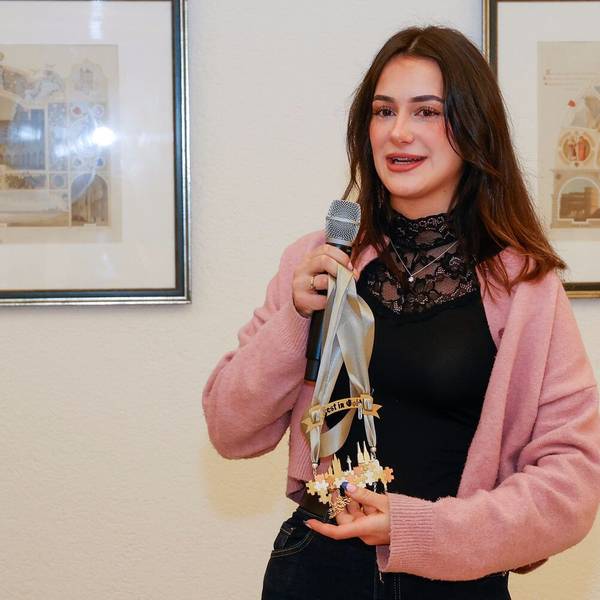 Hannah Homberg hält ein Mikrofon und ihren Orden in der Hand.