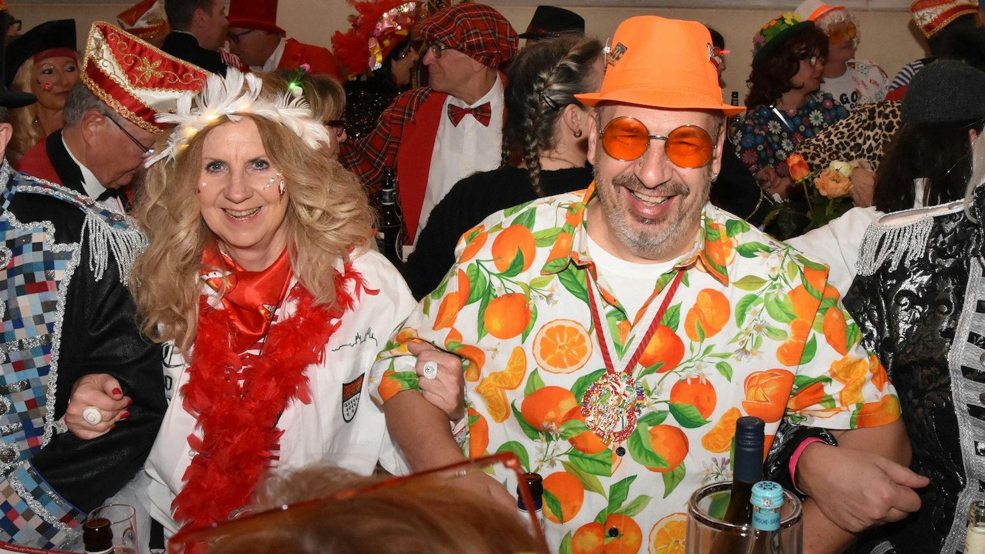 Verkleidete Jecken schunkeln und lachen in die Kamera.