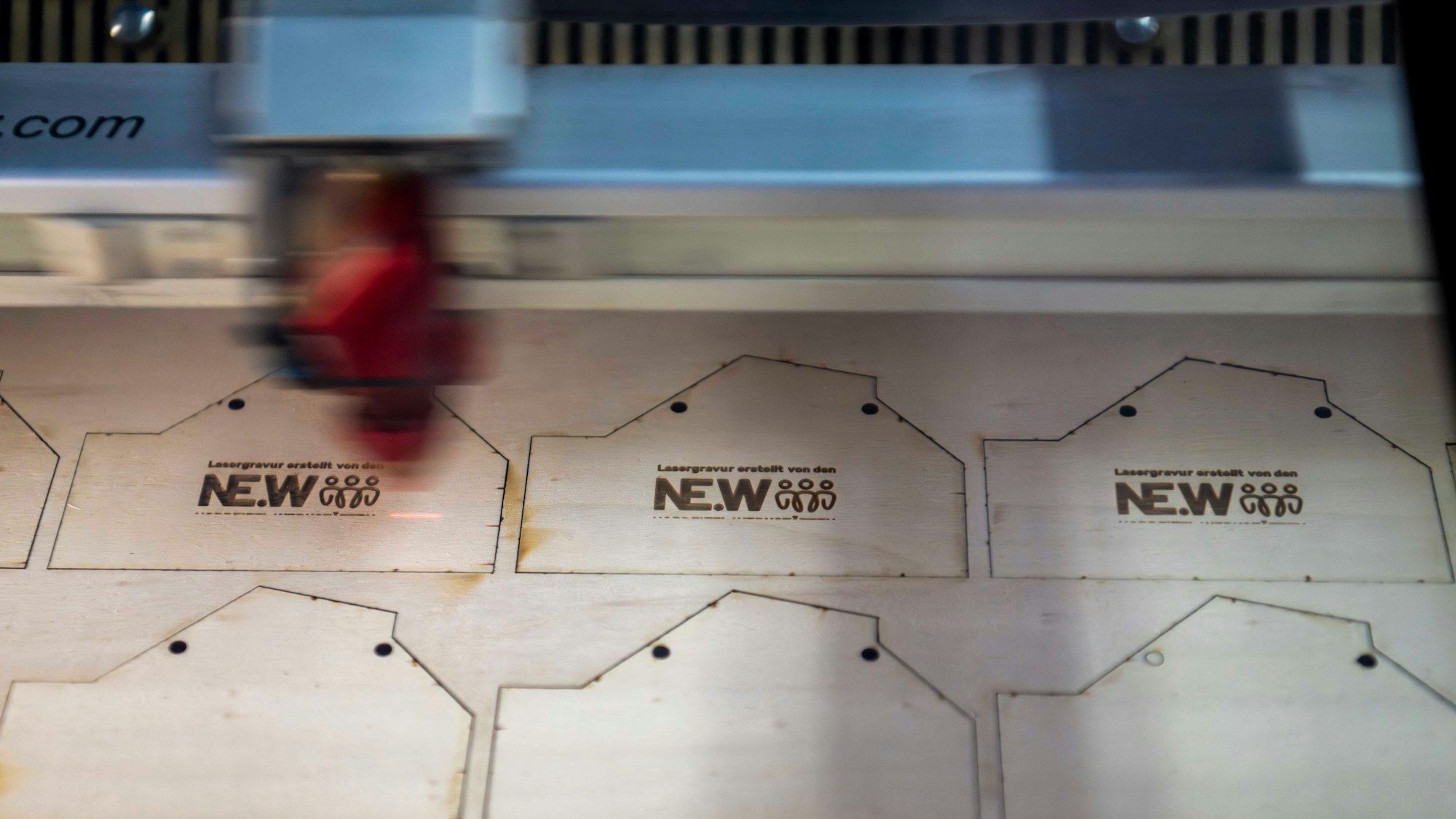 Der Laser schneidet Orden aus einem Holzbrett.