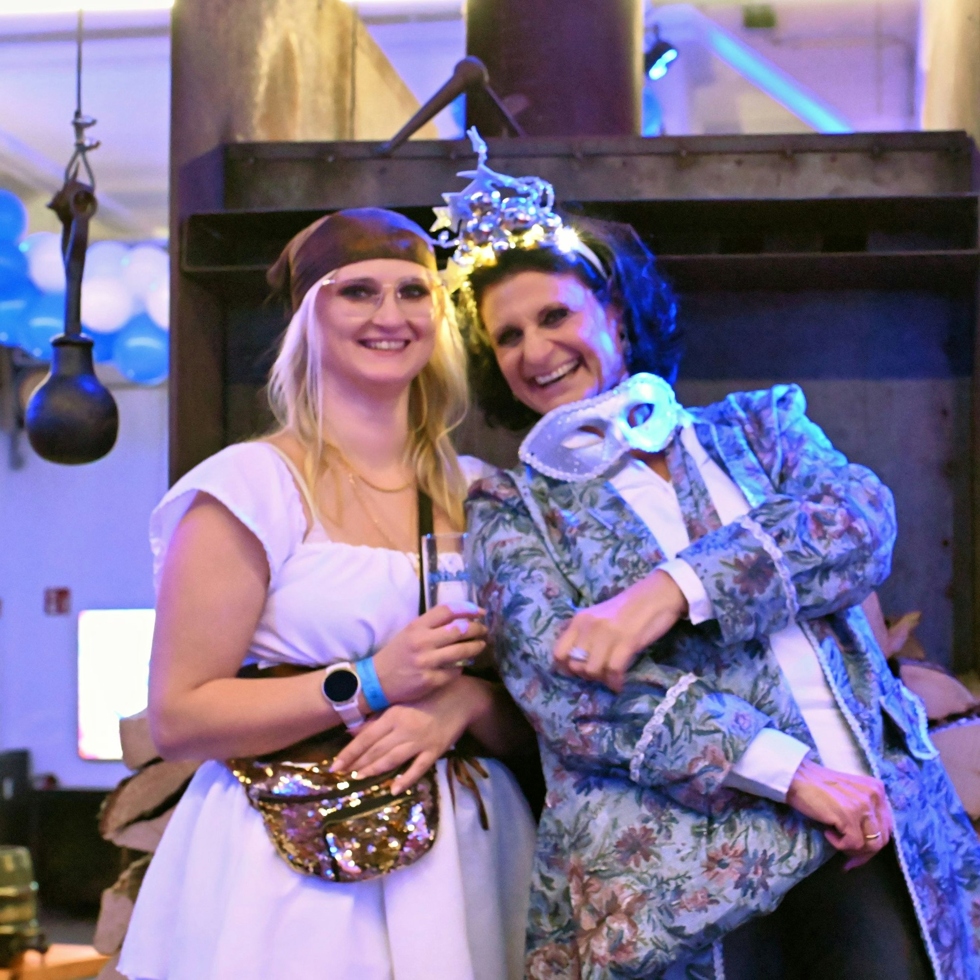 Zwei kostümierte Frauen haben Spaß in der Feuerhalle.