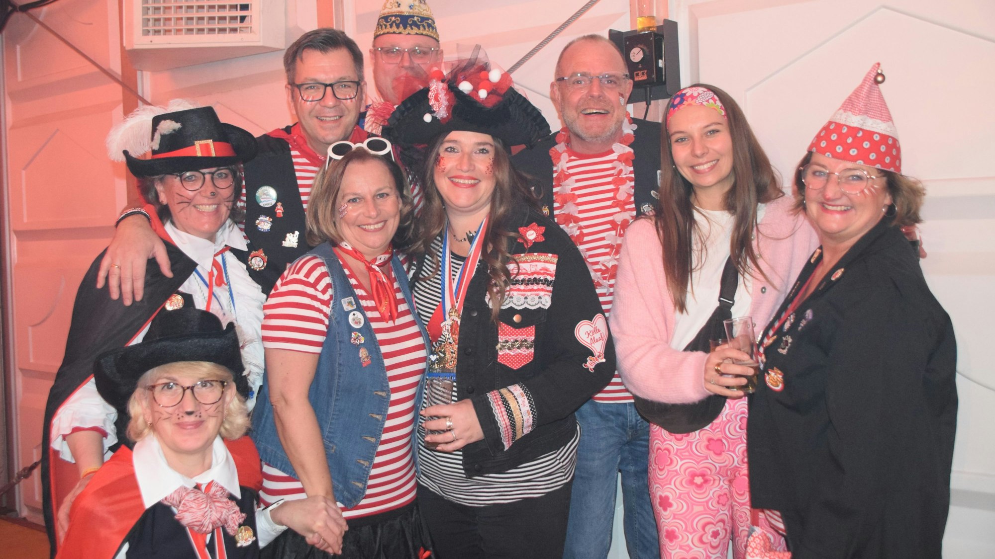 Das Bild zeigt kostümmierte Jecken, gestreift in weiß rot.