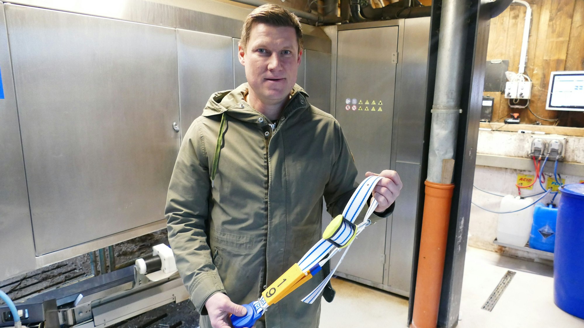 Andreas Trimborn vom Bauerngut Schiefelbusch zeigt einen Sensor, den die Kühe normalerweise um den Hals tragen.